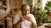 Hombre mayor sonriendo con los ojos cerrados mientras disfruta el aroma de una taza de café de especialidad Freedom Society, ideal como regalo para el Día del Padre.